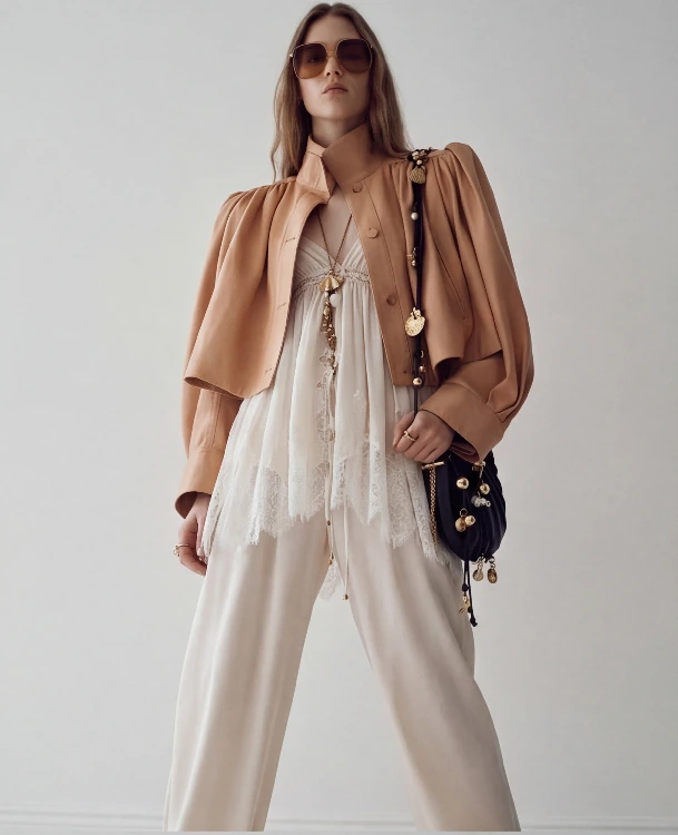 AI lookbook output showing a beige jacket outfit in a low-angle front editorial view