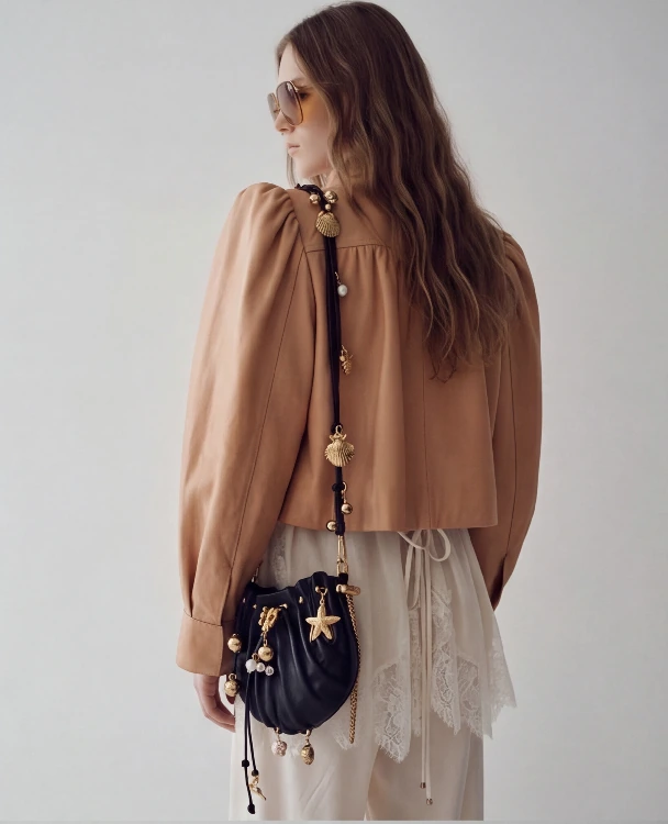 AI lookbook output showing the beige jacket and black bag from a back detail angle